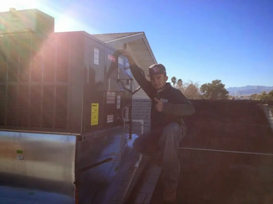 HVAC technician performing AC Tune-Up on a rooftop unit in Attleboro